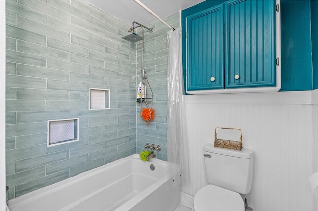 bathroom with shower / tub combo, toilet, and wainscoting