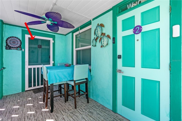 dining space with carpet, ceiling fan, and a textured wall