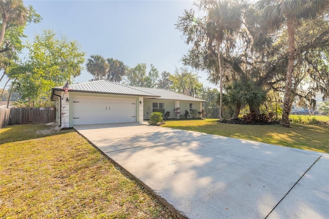 single story home with a garage, driveway, a front lawn, fence, and metal roof