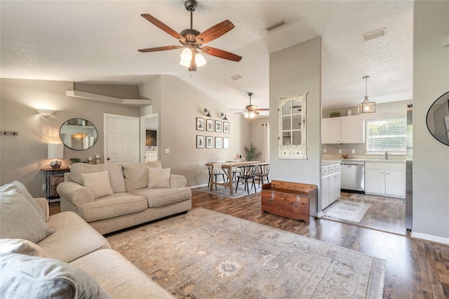 living area with visible vents, lofted ceiling, a textured ceiling, and wood finished floors