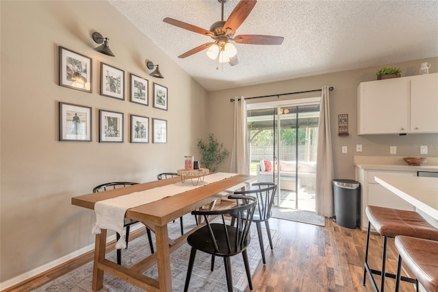 dining space with ceiling fan, baseboards, vaulted ceiling, light wood-style flooring, and a textured ceiling