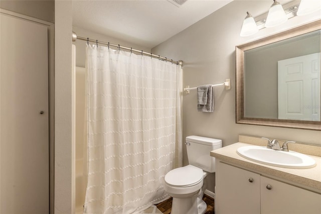 bathroom with vanity, curtained shower, and toilet