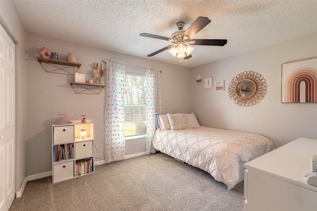 carpeted bedroom featuring baseboards, a textured ceiling, and ceiling fan