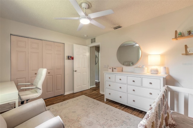 bedroom featuring visible vents, a textured ceiling, and wood finished floors