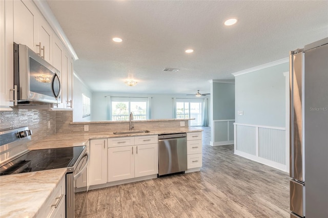 kitchen with visible vents, light wood-type flooring, appliances with stainless steel finishes, white cabinetry, and a sink