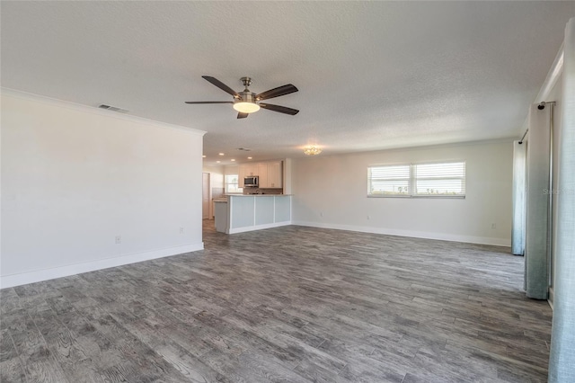 unfurnished living room with visible vents, ornamental molding, a textured ceiling, and wood finished floors