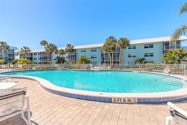 community pool featuring a patio area and fence