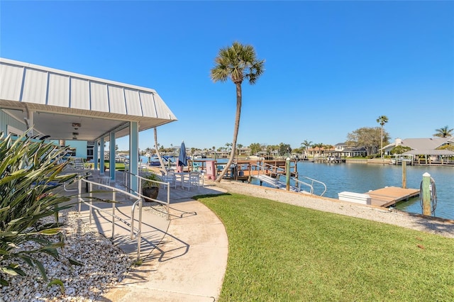 view of dock featuring a lawn and a water view