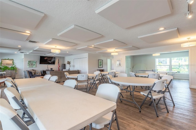 dining room with visible vents, a textured ceiling, and wood finished floors