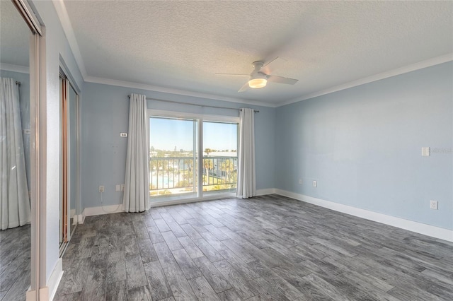 spare room with dark wood-type flooring, baseboards, ceiling fan, ornamental molding, and a textured ceiling