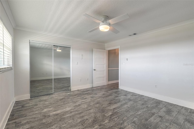 unfurnished bedroom with crown molding, wood finished floors, a closet, and a textured ceiling