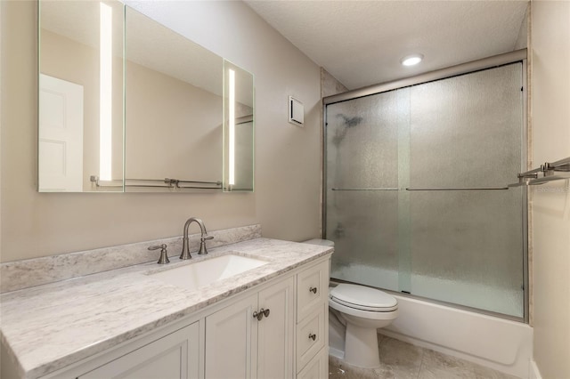 full bathroom featuring tile patterned floors, toilet, a textured ceiling, combined bath / shower with glass door, and vanity