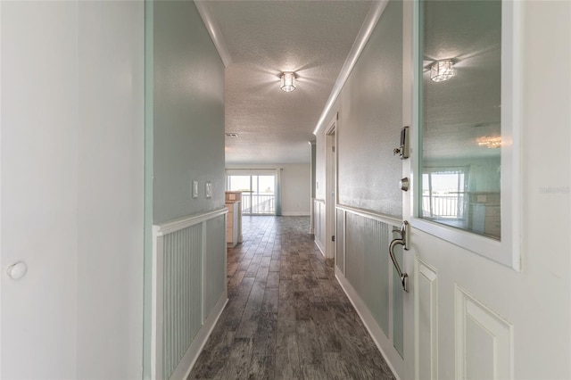 hallway featuring a textured ceiling and dark wood finished floors