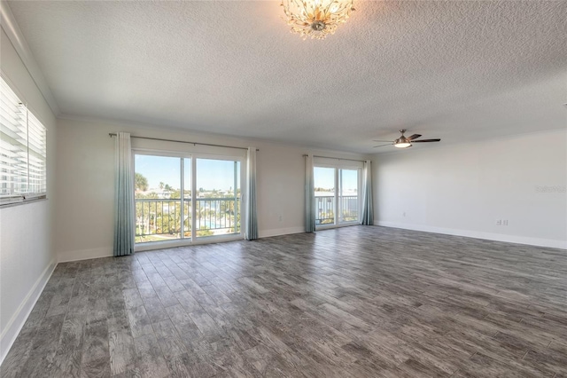 unfurnished living room with dark wood-style floors, a healthy amount of sunlight, and baseboards