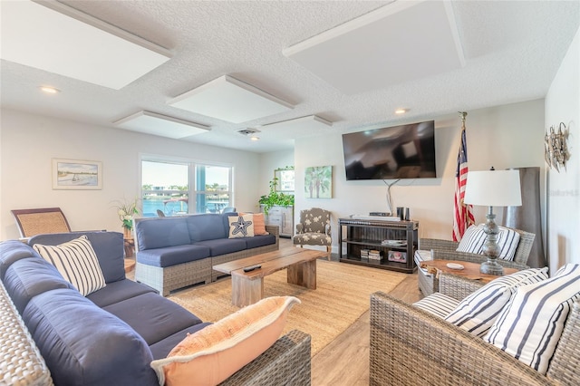 living room featuring light wood-style flooring, recessed lighting, and a textured ceiling