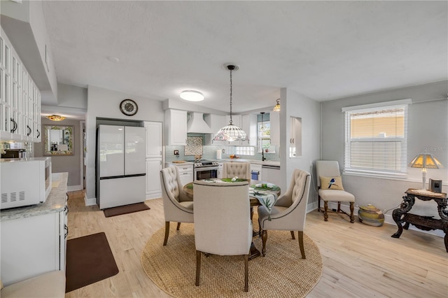 dining space featuring baseboards and light wood finished floors