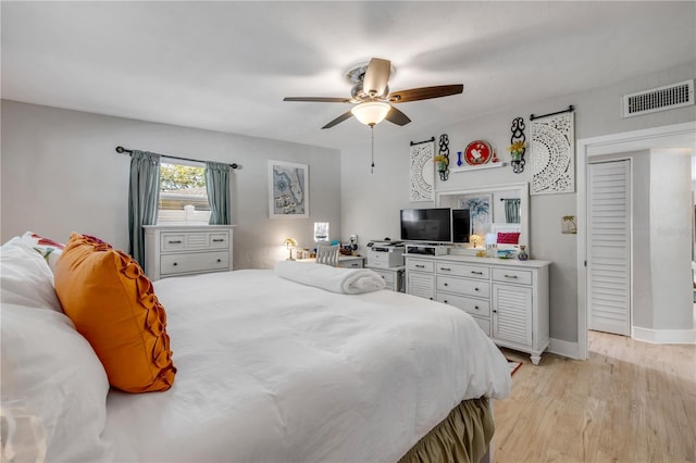 bedroom with visible vents, light wood-style flooring, baseboards, and ceiling fan