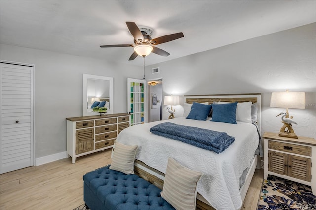 bedroom with ceiling fan, visible vents, baseboards, and wood finished floors