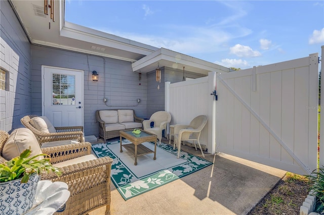 view of patio / terrace featuring fence, outdoor lounge area, and a gate