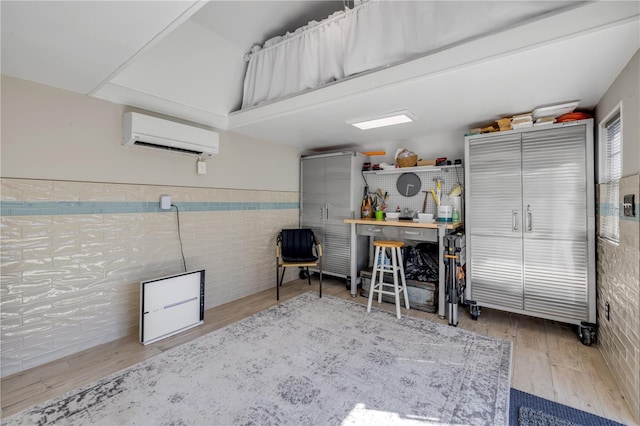 garage featuring a workshop area, wainscoting, and a wall unit AC