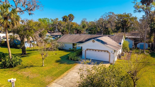 view of front of home with a front lawn, an outdoor structure, an attached garage, and driveway