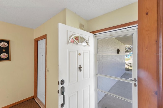 entryway featuring baseboards and a textured ceiling