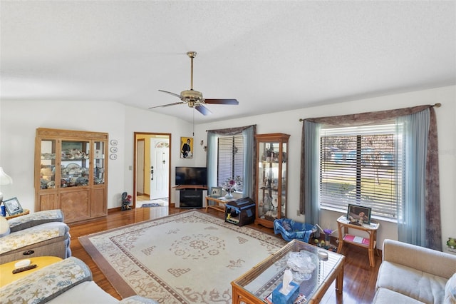 living room with ceiling fan, a textured ceiling, wood finished floors, and vaulted ceiling