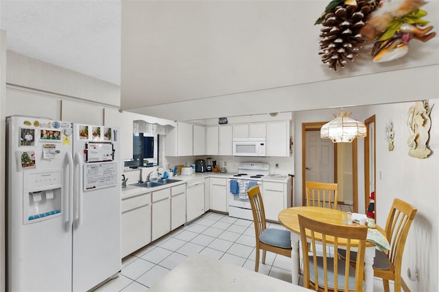 kitchen with white appliances, light tile patterned floors, a sink, light countertops, and white cabinets