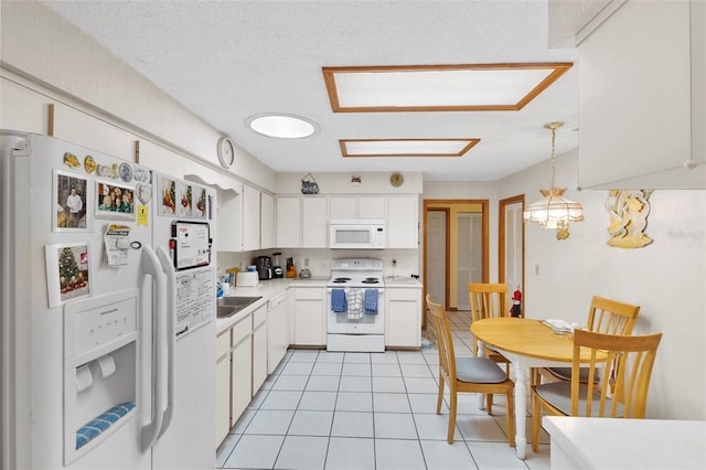 kitchen featuring white cabinetry, white appliances, light countertops, light tile patterned floors, and hanging light fixtures