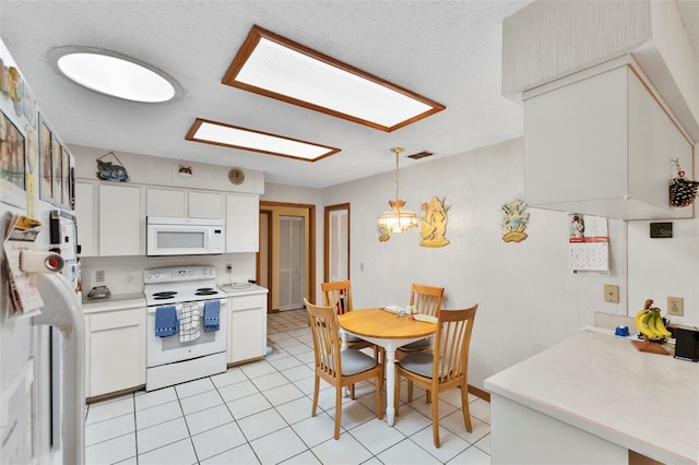 kitchen featuring visible vents, light countertops, light tile patterned floors, white cabinets, and white appliances