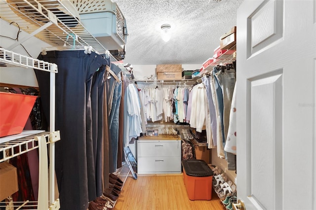 walk in closet with wood finished floors