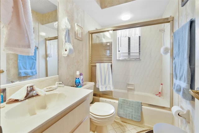 bathroom with tile patterned floors, toilet, vanity, and bath / shower combo with glass door