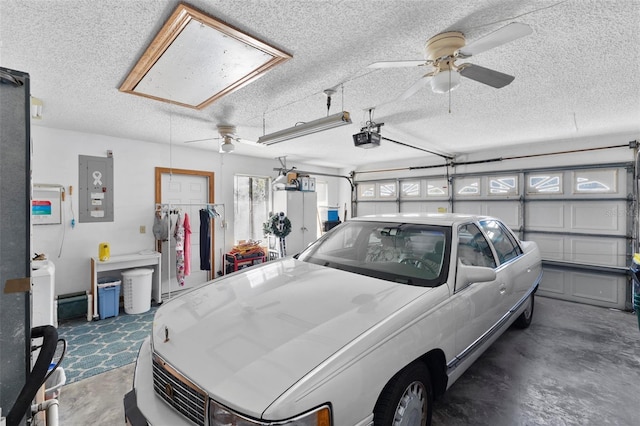 garage featuring electric panel, a garage door opener, and a ceiling fan