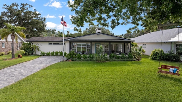 back of house with a porch, decorative driveway, and a yard