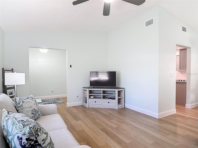 living area with light wood-type flooring, visible vents, and baseboards