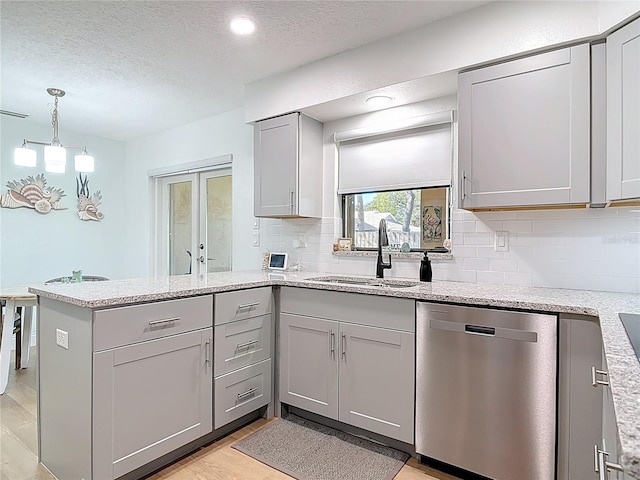 kitchen with gray cabinetry, dishwasher, light wood-type flooring, a peninsula, and a sink