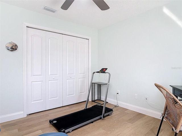 exercise area with visible vents, light wood-style flooring, and baseboards