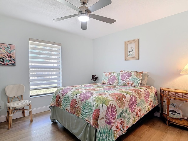 bedroom with wood finished floors, baseboards, and ceiling fan