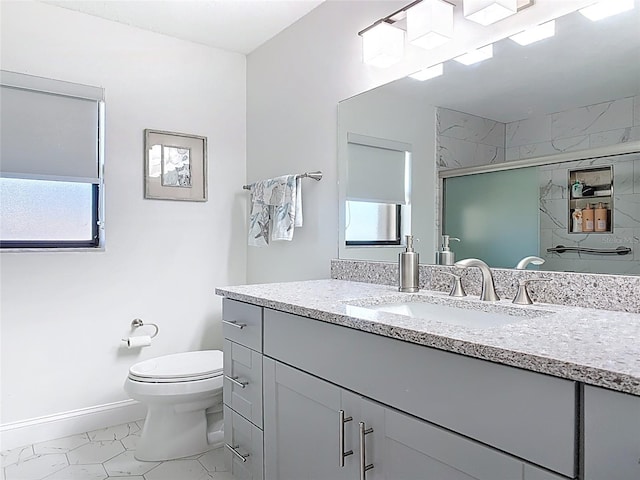 bathroom with a marble finish shower, baseboards, toilet, plenty of natural light, and vanity