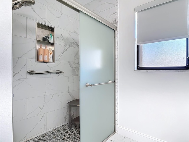 bathroom featuring a shower stall, marble finish floor, and baseboards