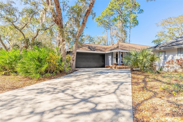 mid-century inspired home with an attached garage and driveway