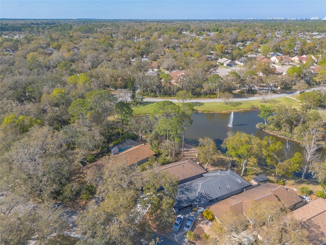 drone / aerial view with a wooded view and a water view