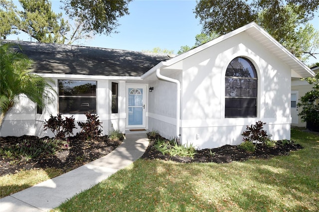 view of front facade featuring a front lawn and roof with shingles