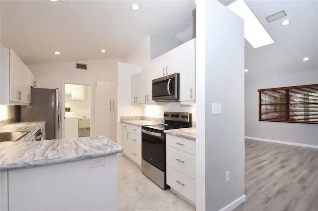 kitchen featuring visible vents, washer / clothes dryer, recessed lighting, appliances with stainless steel finishes, and lofted ceiling with skylight