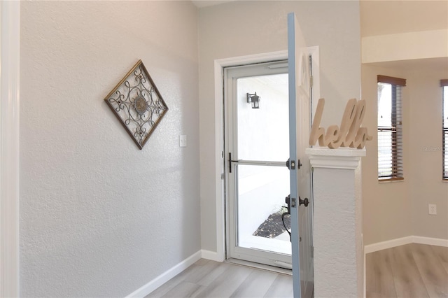 entryway featuring baseboards and light wood-type flooring