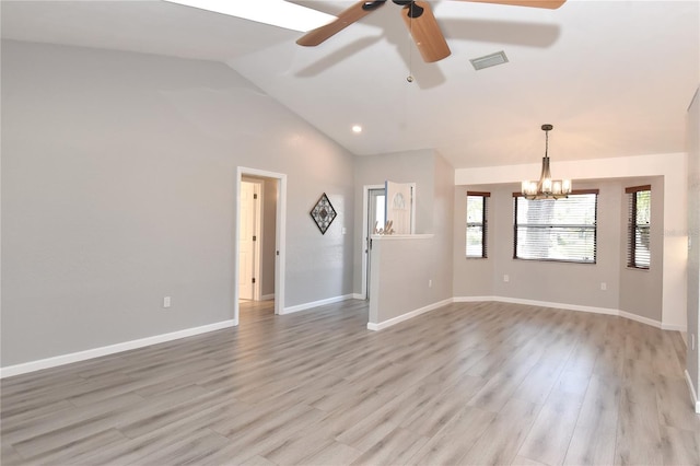 empty room with visible vents, baseboards, light wood-type flooring, vaulted ceiling, and ceiling fan with notable chandelier