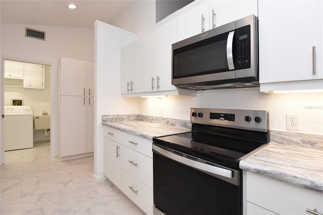 kitchen with visible vents, marble finish floor, appliances with stainless steel finishes, decorative backsplash, and washer / dryer