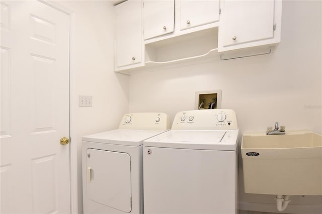 laundry room with separate washer and dryer, cabinet space, and a sink