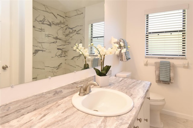 bathroom with vanity, radiator, toilet, and baseboards