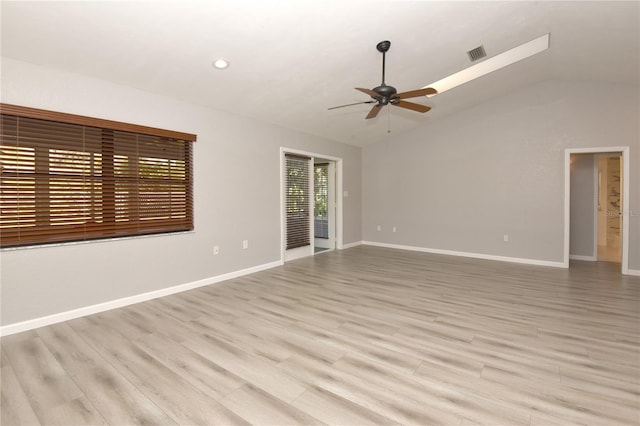 spare room featuring visible vents, baseboards, lofted ceiling, light wood-style floors, and a ceiling fan